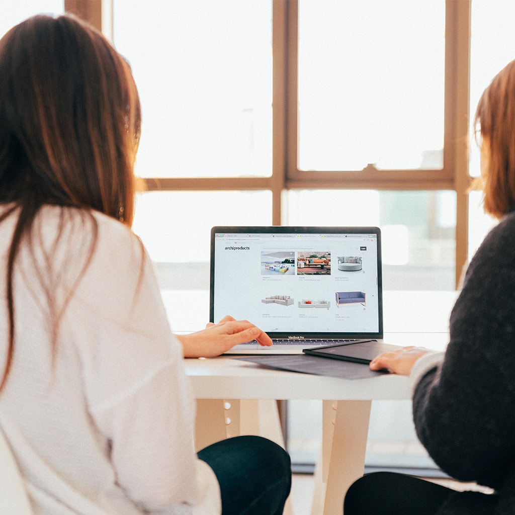 Zwei Frauen in einer Besprechung vor einem Laptop